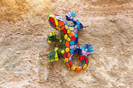 A colorful ceramic gecko on a stone wallの写真素材