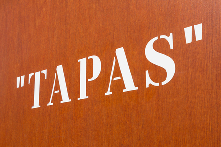 Large stencil "Tapas" letters on an orange wallの写真素材
