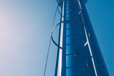 Closeup of a secured ladder on a blue metal towerの写真素材