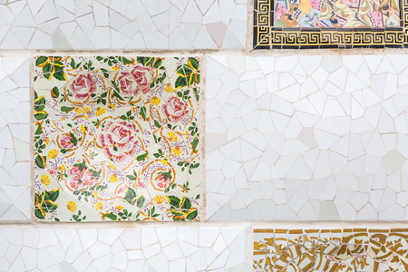 Colorful broken tiles mosaic with floral pattern at Parc Guell, Barcelona, Spain