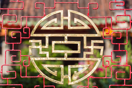 Stylized chinese characters made into a round vietnamese symbol for blessings like happiness, luck and longevity in front of a temple in Hoi An, Vietnamの写真素材