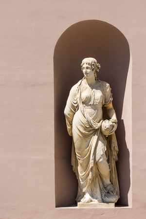Classic antique stone statue of a woman in a public wall in Triest, Italyの写真素材