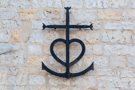 Metal Camargue cross from provencal Saintes Maries de la Mer symbolizing the three cardinal virtues: faith (cross), charity (heart) and hope (anchor)の写真素材