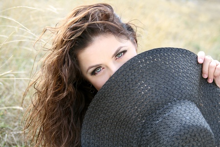 Young attractive lady hiding her face behind the bonnetの写真素材