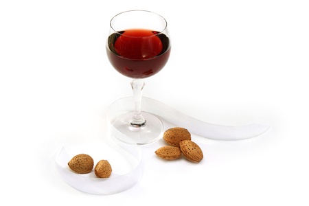 Glass of red wine and almonds on white backgroundの写真素材