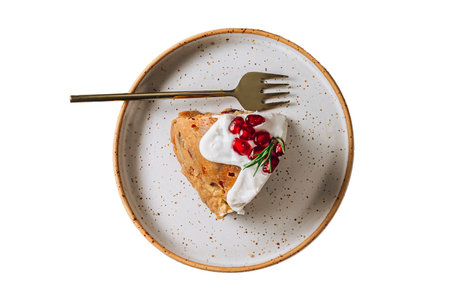 Piece of cake with whipped cream and pomegranate seedsの写真素材