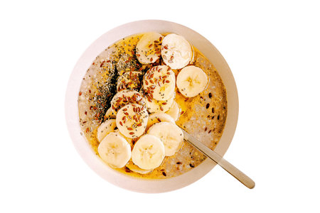 Bowl of oatmeal with banana and chia seeds isolated on white backgroundの写真素材