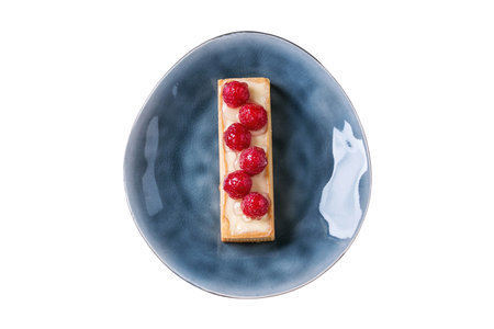 Cake with raspberries on a blue plate isolated on white background