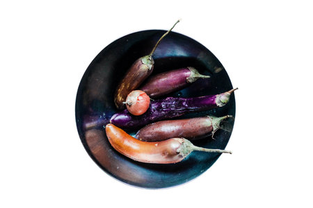 Fresh eggplants in a ceramic bowl isolated on white background.の写真素材
