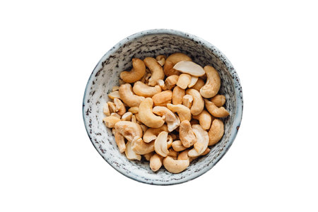 Roasted cashew nuts in a bowl isolated on white background.の写真素材