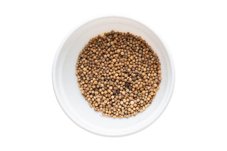 Coriander seeds in white bowl isolated on white background, top viewの写真素材