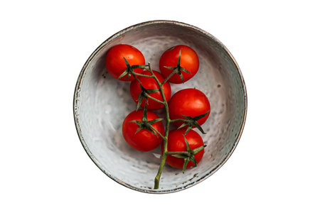 Cherry tomatoes in a bowl isolated on white background. Top view.の写真素材
