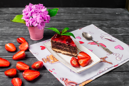 Piece of chocolate cake with strawberries on the tableの写真素材