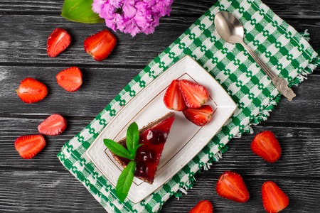 Piece of chocolate cake with strawberries on the tableの写真素材