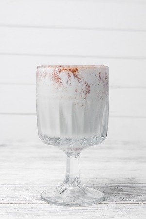 Shake in a glass with syrup and straws on a wooden tableの写真素材