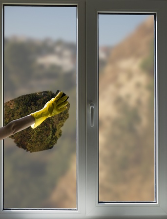 A person cleaning the window with a gloveの写真素材