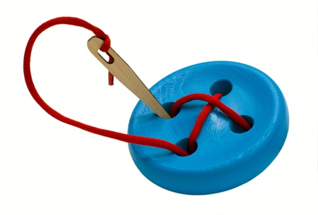 Button with needle for training fine motor skills