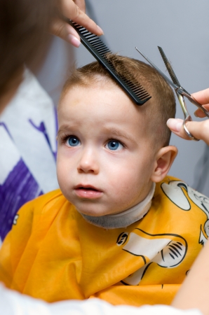 Haircutting one year old boy in the hairdressing saloonの写真素材
