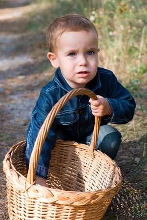 Cute boy with basket in a forestの写真素材