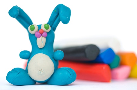 Funny blue plasticine rabbit on the background pieces of plasticineの写真素材