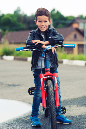 Cute boy riding bike in a cityの写真素材