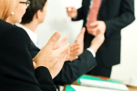 Business team applauding after a successful business presentation (selective focus only on hand in...