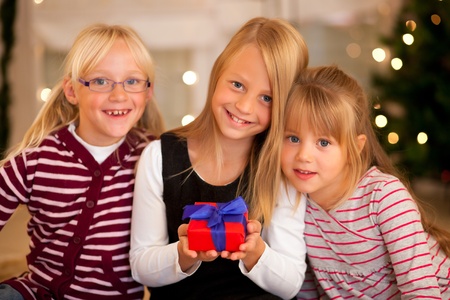 Three Girls in front of a Christmas tree with presentsの写真素材