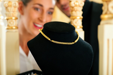 Woman at the jeweller is looking for jewelleryの写真素材