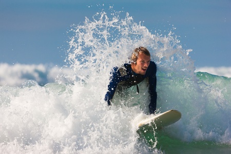 Surfer with his board in the waves entering the seaの写真素材