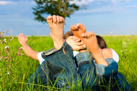 Happy couple lying on a meadow in summerの写真素材