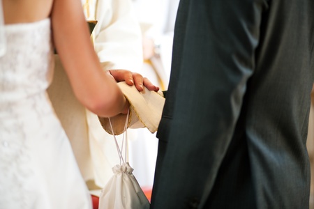 Priest giving blessing to a couple at a wedding ceremony in a churchの写真素材