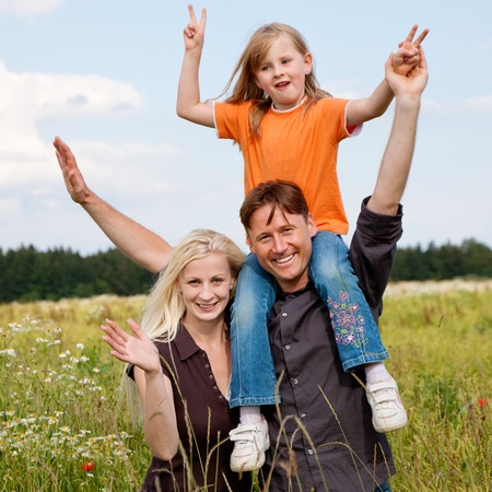 Family with a kid carrying their child on their shouldersの写真素材