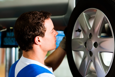 Auto mechanic in his workshop changing tires or rimsの写真素材