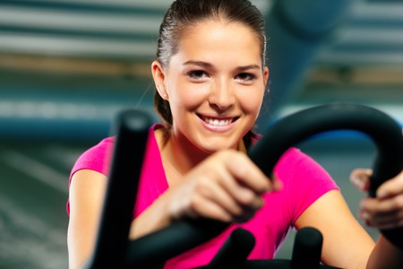 Woman spinning in the gym, exercising their legs doing cardio training on bicycle