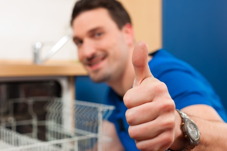 Technician or plumber repairing the dishwasher in a householdの写真素材