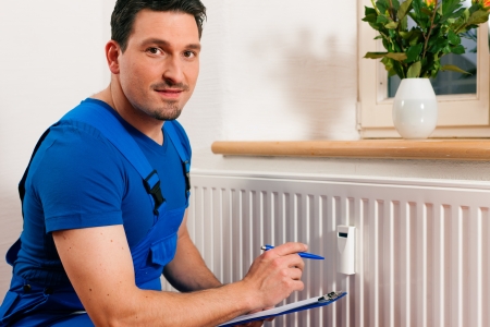 Technician reading the heat meter to check consumptionの写真素材