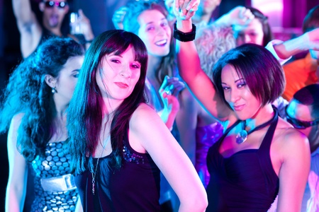 Dance action in a disco club - group of friends, men and women of different ethnicity, dancing to...