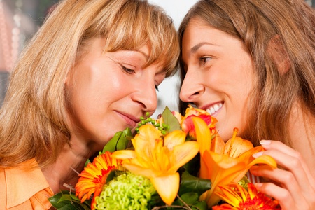 Mother and daughter â the daughter has given her mother flowers   の写真素材