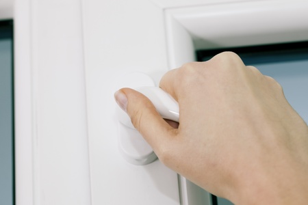 Female hand opening or closing a window using the handle の写真素材