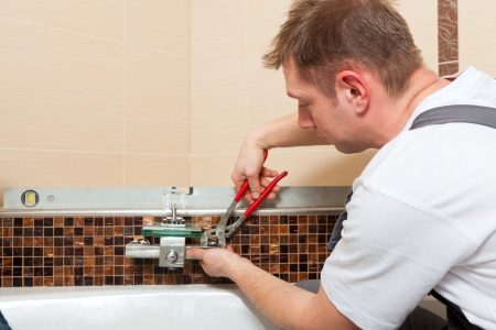 Plumber installing a mixer tap in a bathroom   の写真素材