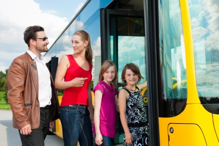 Passengers boarding a bus at a bus stationの写真素材