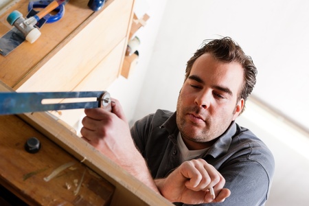 Carpenter working with angle and pencil in his workshop