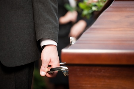 Religion, death and dolor  - coffin bearer carrying casket at funeral to cemeteryの写真素材