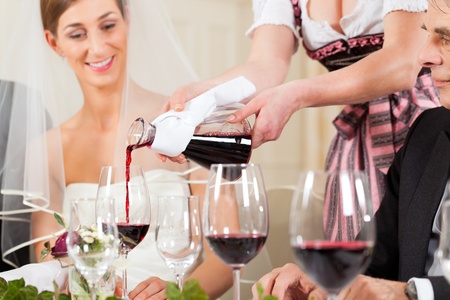Wedding party at dinner - wine is be poured into glassesの写真素材