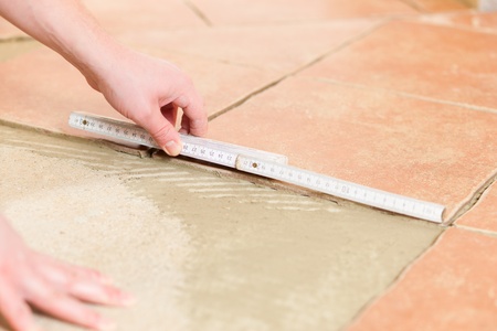 Construction worker is tiling at homeの写真素材