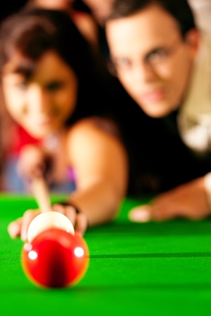 Couple  man and woman  in a billiard hall playing snookerの写真素材