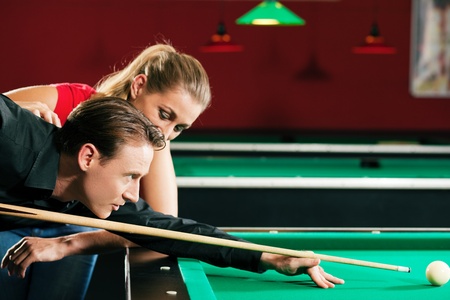 Couple  man and woman  in a billiard hall playing Poolの写真素材