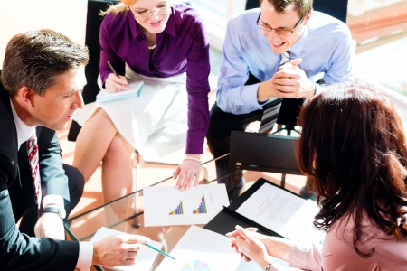 Business people having meeting or workshop in office checking profit growth graph and documents Business people having meeting or workshop in office checking profit growth graph and documents