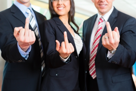 Business - group of businesspeople posing for group photo in office showing the finger Business - group of businesspeople posing for group photo in office showing the finger