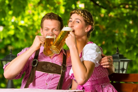 Happy Couple sitting in Beer garden in summer and enjoy a glass of beer and the sunの写真素材